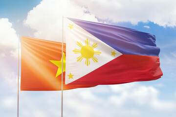 Sunny blue sky and flags of philippines and vietnam