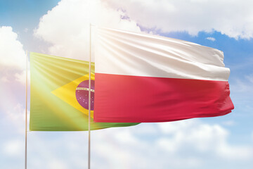 Sunny blue sky and flags of poland and brazil