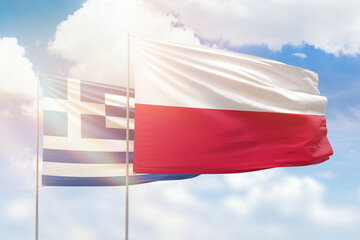 Sunny blue sky and flags of poland and greece