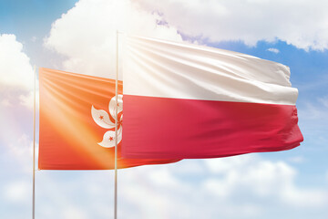 Sunny blue sky and flags of poland and hong kong