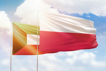 Sunny blue sky and flags of poland and kuwait