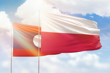 Sunny blue sky and flags of poland and laos