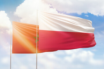 Sunny blue sky and flags of poland and morocco