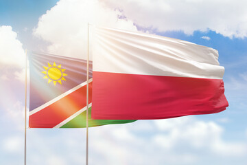Sunny blue sky and flags of poland and namibia