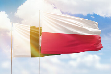 Sunny blue sky and flags of poland and pakistan