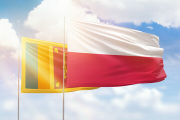 Sunny blue sky and flags of poland and sri lanka