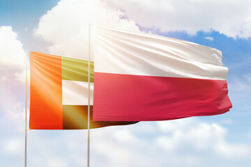 Sunny blue sky and flags of poland and uae