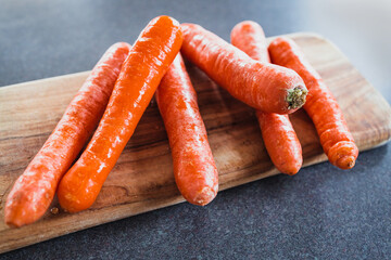 close-up of fresh carrots on wooden chopping board, simple ingredients concept