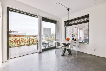 Fancy lamp hanging on ceiling over stylish furniture in spacious living room in modern flat