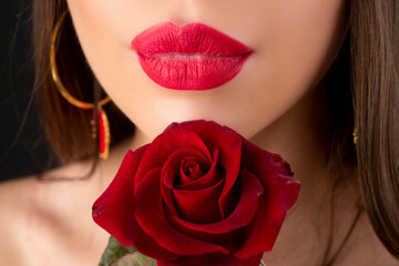 Fototapeta na wymiar Lips with lipstick closeup. Beautiful woman lips with rose. Lipstick cosmetics makeup, fashion and beauty.