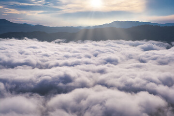 Aerial view of sunrise above fluffy sea fog misty clouds with mountain hill from Aiyoeweng Sky walk on Betong, Yala. Abstract nature landscape background in morning.