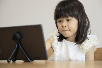 タブレットで動画を見る女子小学生 (7歳)