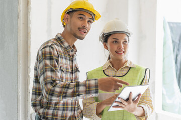 Asian contractor and engineer inspecting material in construction building.