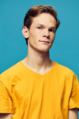 vertical portrait of a guy in a yellow T-shirt on a blue background