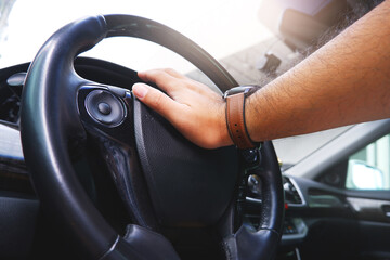 Naklejka premium Driver hand pressing on steering wheel honking horn