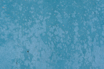 Texture of worn blue painted surface of particle board. Faded surface with many light spots, cracked and partially peeled off, abstract background, high resolution.