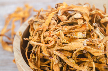 Dried cordyceps militaris mushroom flower on wooden background.