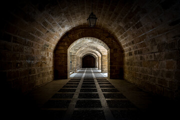 Architecture photography with converging lines from dark to light of vaulted passage in the walls...