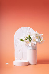 Natural minimal beauty wooden pedestal. Empty cosmetics podiums for product on red background with jasmine flowers