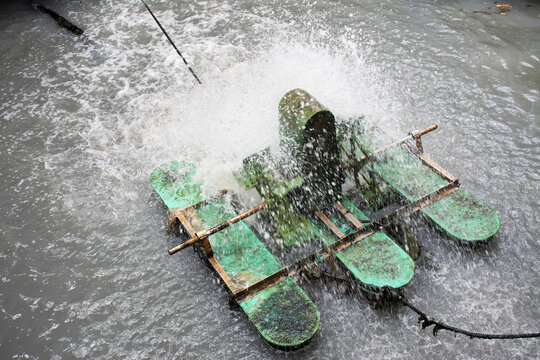 Oxygen generation surface aerator machinery in sludge wastewater working moving windmill system for treatment water on pool pond in garden park at Nonthaburi, Thailand