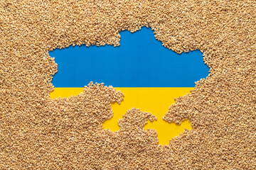 Political map of Ukraine laid out with grain of wheat on the background of the Ukrainian flag....