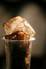 plastic drinking glass full with used tea bags. close up