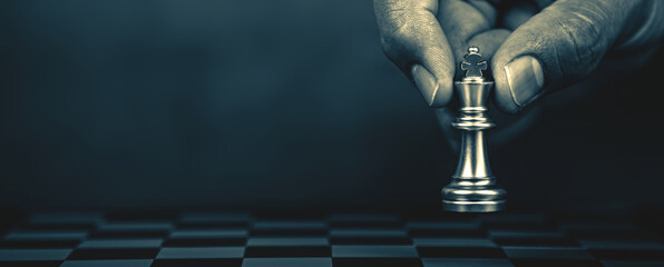 Hand choose king chess on chessboard concept of challenge or team player or business team and leadership strategy or strategic planning and human resources organization risk management.