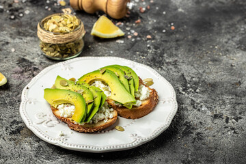 Toasts with avocado rye bread, sliced avocado, pumpkin seeds for breakfast or lunch. Vegetarian sandwiches. Healthy, clean eating concept. Vegan or gluten free diet. top view