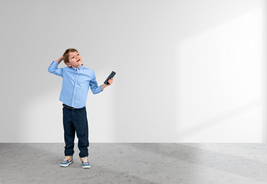 Child with phone in hand, thinking on white background. Copy spa