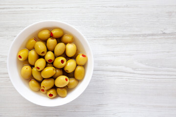 Marinated Green Olives with Pimento Peppers in a Bowl, top view. Flat lay, overhead, from above. Copy space.