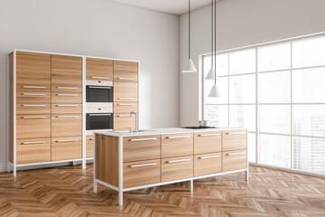 Light kitchen interior with countertop and sink, shelves and panoramic window