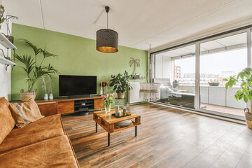 Modern spacious room with sofa and TV in loft style with glass windows and balcony door