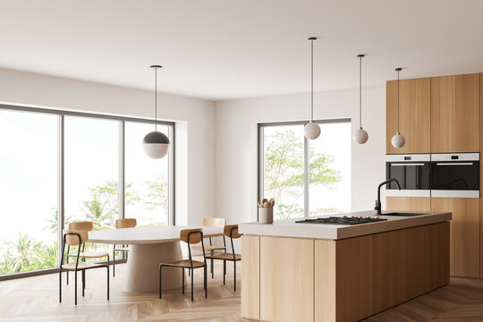 Stylish kitchen interior with chairs and island, eating space and panoramic window