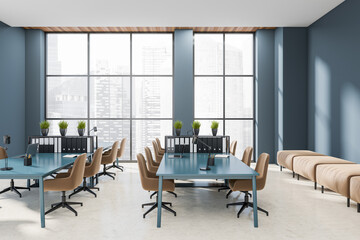 Workplace interior with laptop on desk, couch and panoramic window on city view