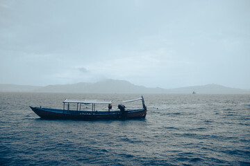 Traditional fishing boat moored at sea on a rainy day in Koh Sdach Island, Cambodia