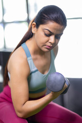 Fototapeta na wymiar Indian woman working out with dumbbells