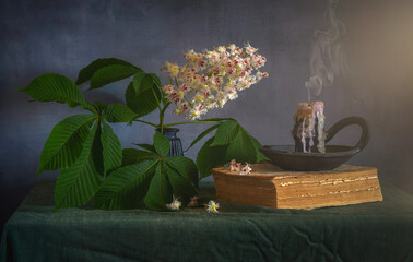 Chestnut flowers on a branch with leaves and an extinguished candle. Morning.