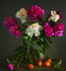 a bouquet of beautiful freshly cut peonies on the table and ripe apricots