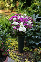 Friedhofsvase mit bunten Blumen im Sommer auf einem Grab