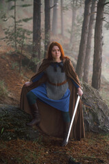 Fototapeta premium Portrait red-haired girl in armor and raincoat in forest