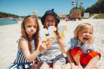 Three children eat ice cream on the beach. a child with down syndrome leads a normal life