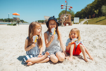 Three children eat ice cream on the beach. a child with down syndrome leads a normal life