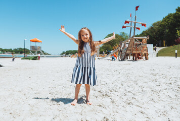 happy little girl with down syndrome having fun on the beach