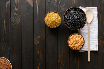 Different type of composition of raw dry legumes and cereals. Black beans, bulgur, peas and buckwheat.