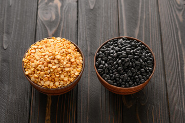 Fresh organic natural beans and peas on wooden rustic black background