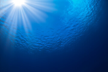 Fototapeta premium Ocean blue background with rays of sun