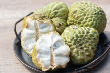 Custard apple and halved fruit on wooden background