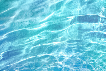 Beautiful turquoise blue ocean water surface with light reflections and highlights. Texture of...