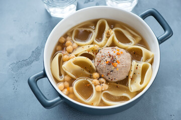 Serving pan with catalan escudella on a grey concrete background, horizontal shot, elevated view
