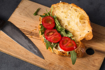 Croissant with sauce and arugula and tomato